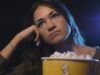 Woman watching a boring movie at the cinema